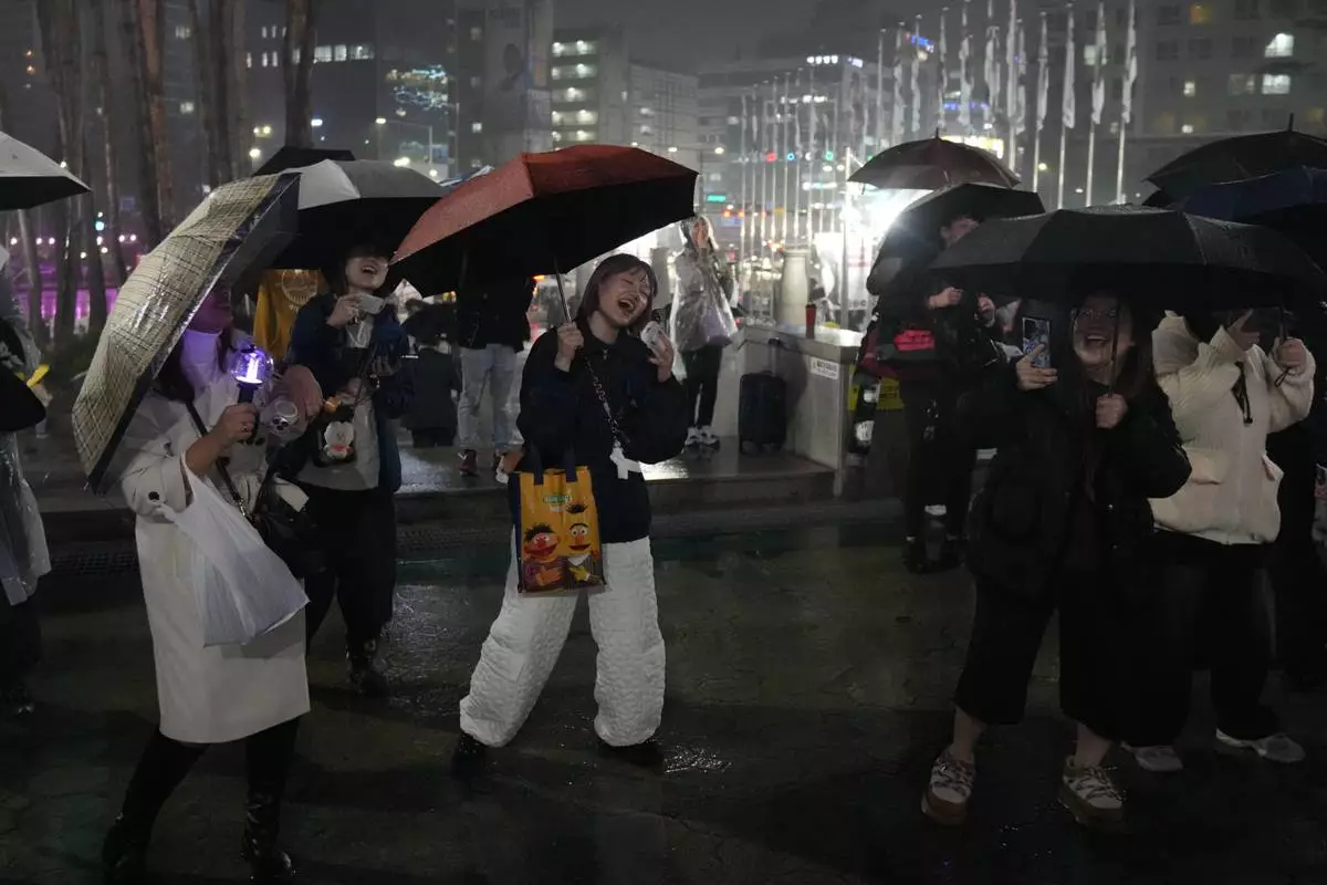 Fans of K-pop band BTS react outside of the stadium where K-pop band BTS is performing the World Tour Arirang in Goyang, South Korea, Thursday, April 9, 2026. (AP Photo/Lee Jin-man)