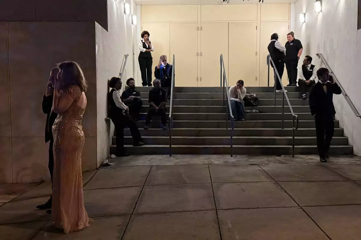 Attendees and hotel workers evacuate after an incident at the Washington Hilton during the White House Correspondents Dinner, Saturday, April 25, 2026, in Washington. (AP Photo/Mark Schiefelbein)