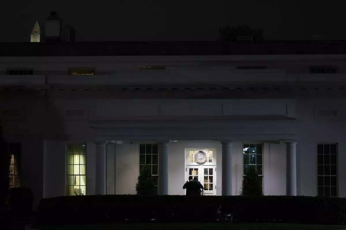 People are seen outside the West Wing driveway entrance of the White House, Saturday, April 25, 2026, in Washington. (AP Photo/Tom Brenner)