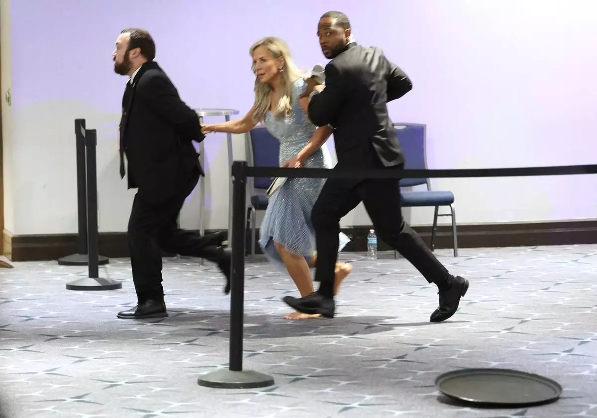 Guests are assisted and whisked away during the White House Correspondents Dinner, Saturday, April 25, 2026, in Washington. (AP Photo/Tom Brenner)