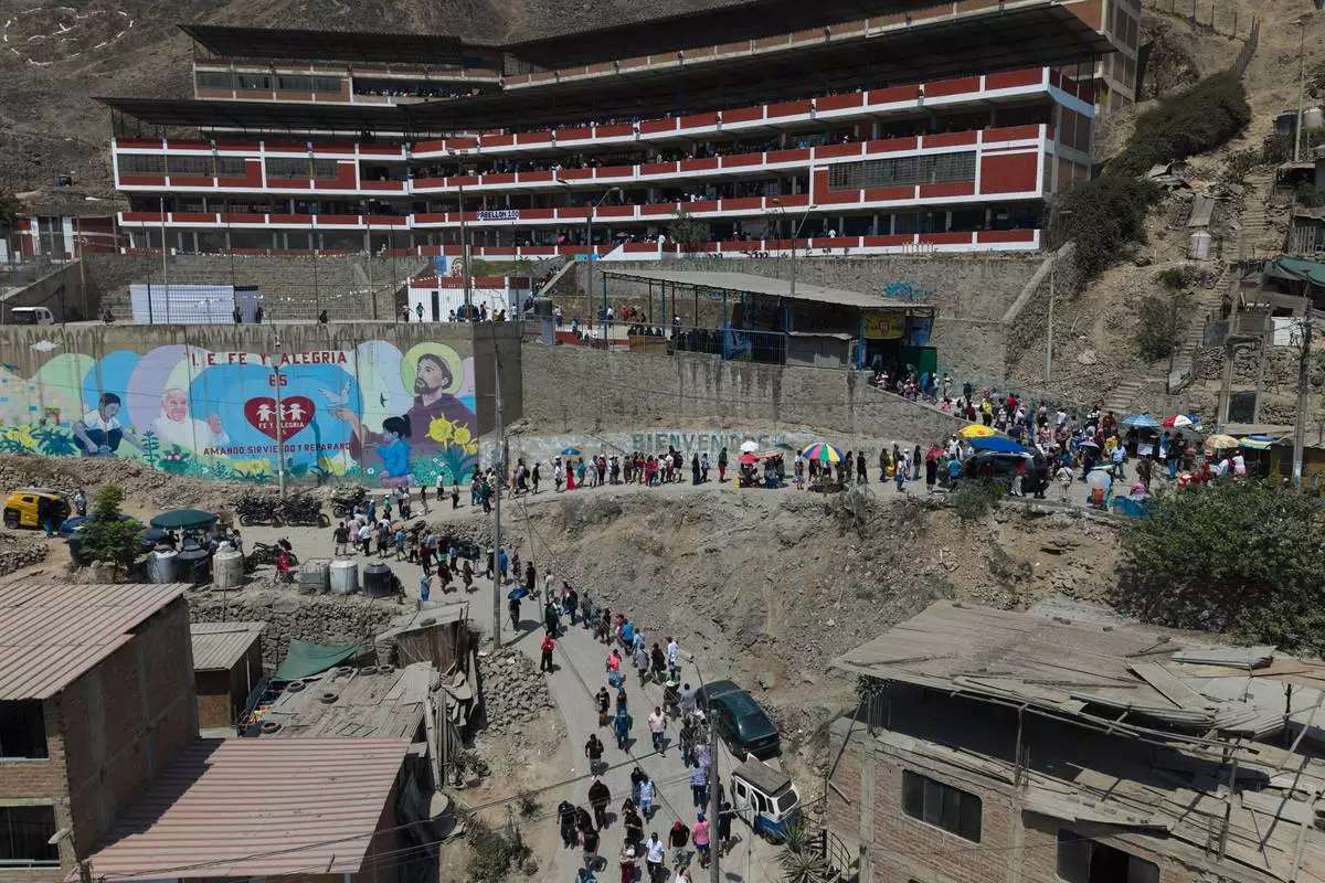 Voters line up outside a polling station during general elections in Lima, Peru, Sunday, April 12, 2026. (AP Photo/Guadalupe Pardo)