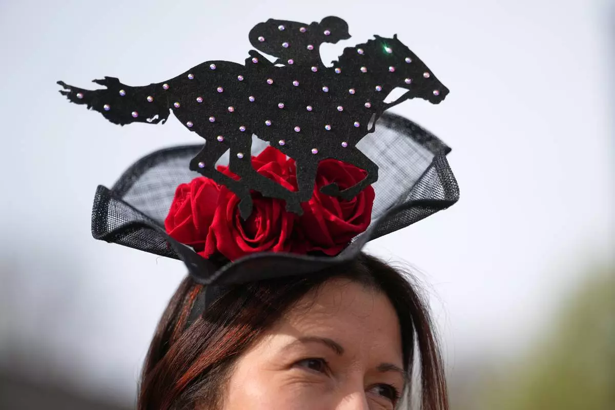 A racegoer wears a racing themed hat as she arrives to attend Ladies Day, the second day of the Grand National Horse Racing festival, at Aintree racecourse, near Liverpool, England, Friday, April 10, 2026. (AP Photo/Jon Super)