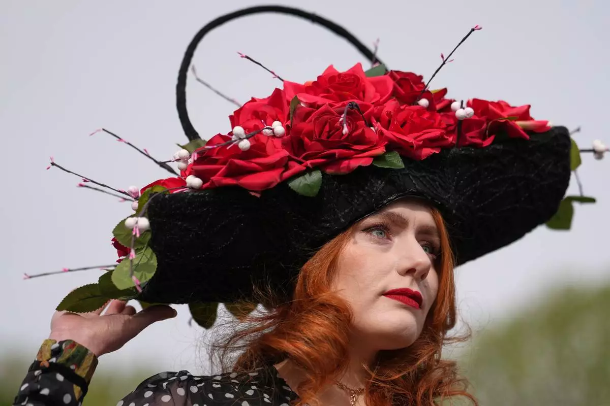 Charlotte Hawes wears a hat by House of Charles as she arrives to attend Ladies Day, the second day of the Grand National Horse Racing festival, at Aintree racecourse, near Liverpool, England, Friday, April 10, 2026. (AP Photo/Jon Super)
