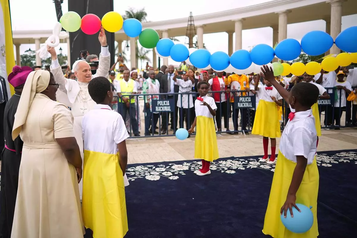 Before celebrating Mass, Pope Leo XIV Leo joins in with children to help release into the sky balloons tied in the shape of a rosary, at the Basilica of the Immaculate Conception of Mongomo, Equatorial Guinea, Wednesday, April 22, 2026, on the tenth day of his 11-day pastoral visit to Africa. (AP Photo/Andrew Medichini)