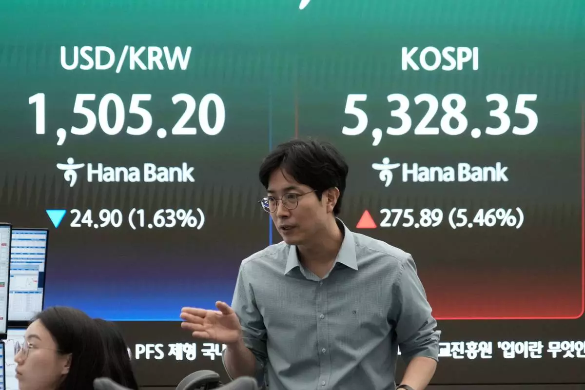 A currency trader reacts near a screen showing the Korea Composite Stock Price Index (KOSPI), right, and the foreign exchange rate between U.S. dollar and South Korean won at the foreign exchange dealing room of the Hana Bank headquarters in Seoul, South Korea, Wednesday, April 1, 2026. (AP Photo/Ahn Young-joon)