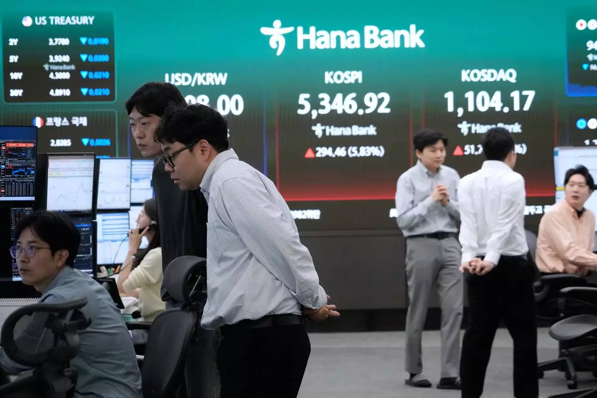 Currency traders work at the foreign exchange dealing room of the Hana Bank headquarters in Seoul, South Korea, Wednesday, April 1, 2026. (AP Photo/Ahn Young-joon)