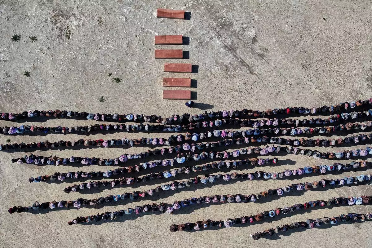 FILE - Mourners pray over the six coffins of members of the Al-Jalib family, who were killed Wednesday in Israeli strikes in Beirut, during their funeral in the village of al-Sour, Deir al-Zour province, northeastern Syria, Saturday, April 11, 2026. (AP Photo/Ghaith Alsayed, File)
