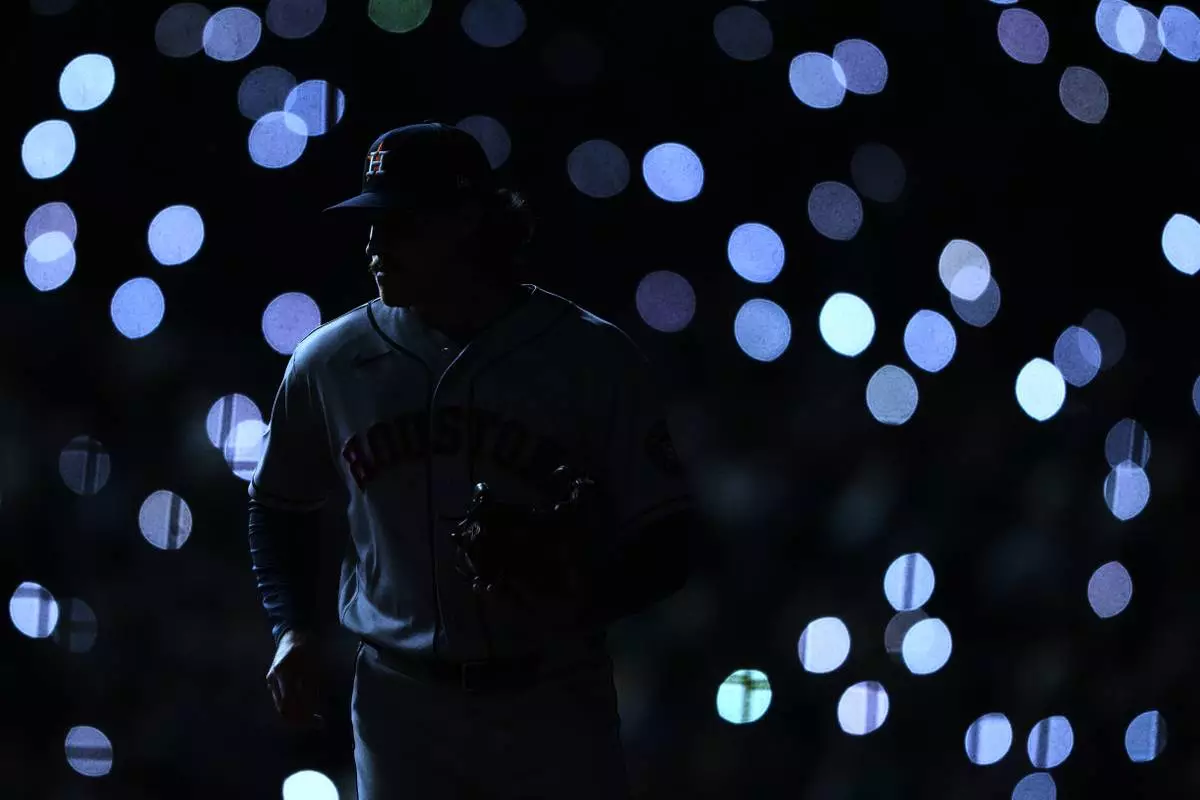 FILE - Houston Astros relief pitcher Bryan King warms up before facing the Seattle Mariners as fan turn their phone lights on during the sixth inning of a baseball game, Saturday, April 11, 2026, in Seattle. (AP Photo/Lindsey Wasson, File)