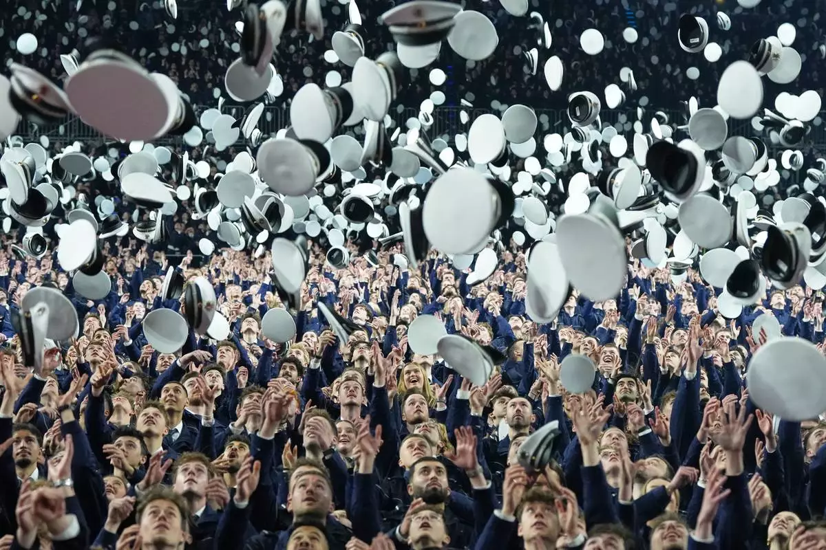 FILE - New young German police officer trainees throw their hats in the air after taking their oath of service and officially entering the service for security, law and democracy in Cologne, Germany, Wednesday, April 15, 2026. (AP Photo/Martin Meissner, FIle)