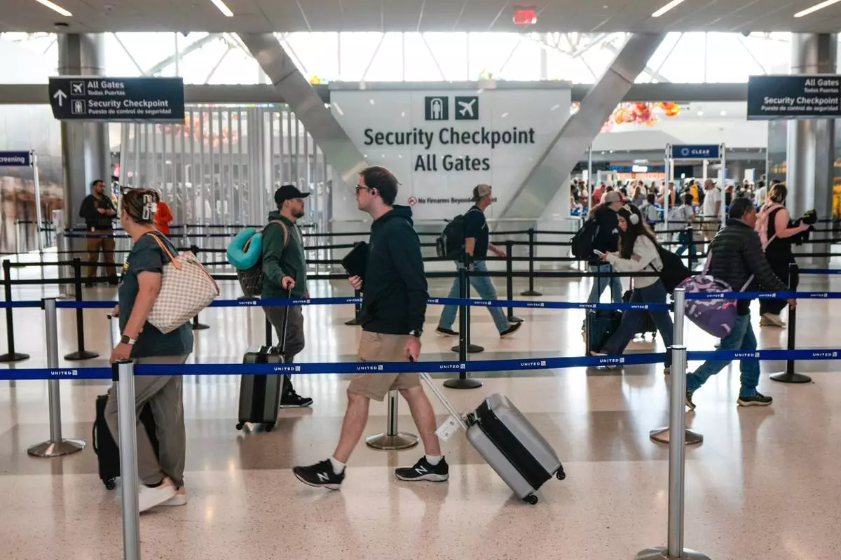 FILE - Airline passengers make their way through the security lines in Terminal E at George Bush Intercontinental Airport, in Houston, Sunday, March 29, 2026. (Brett Coomer/Houston Chronicle via AP, File)