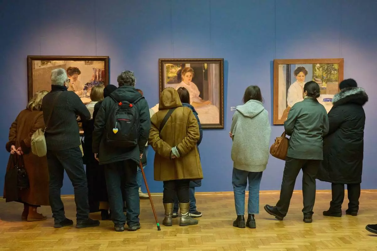 Visitors at Ukraine's National Art Museum bundle up due power outages caused by Russian air attacks on the country's energy system during winter in Kyiv, Ukraine, Friday, Feb. 6, 2026. (AP Photo/Efrem Lukatsky)