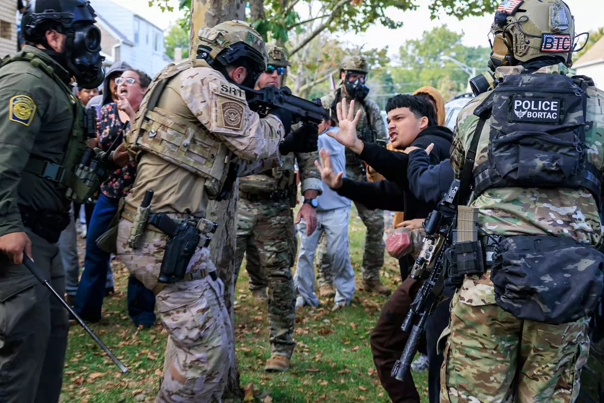 FILE - A law enforcement officer points a crowd control weapon at a protester in East Side, Chicago, Oct. 14, 2025. (Anthony Vazquez/Chicago Sun-Times via AP, File)