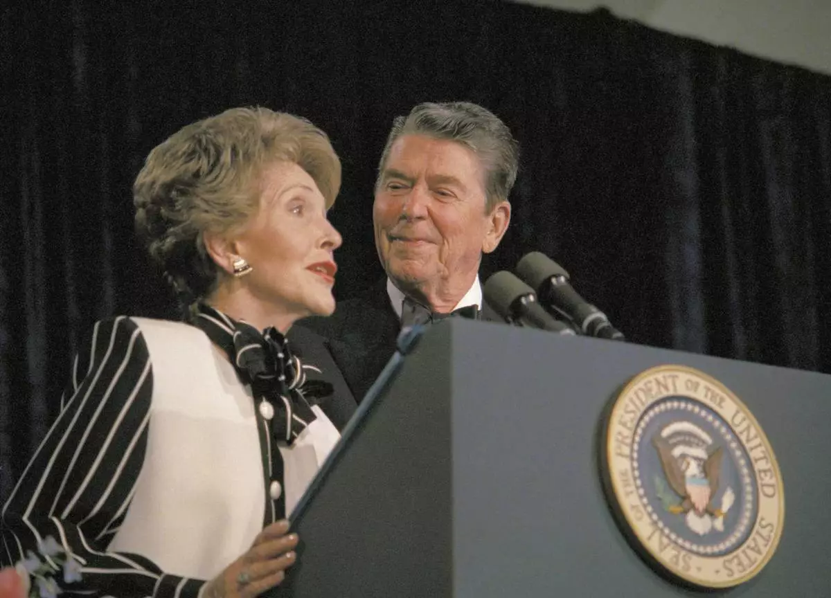 FILE - President Ronald Reagan watches as first lady Nancy Reagan comments from the podium during the White House Correspondents' Association annual dinner on April 23, 1987, in Washington. (AP Photo/Charles Tasnadi, File)