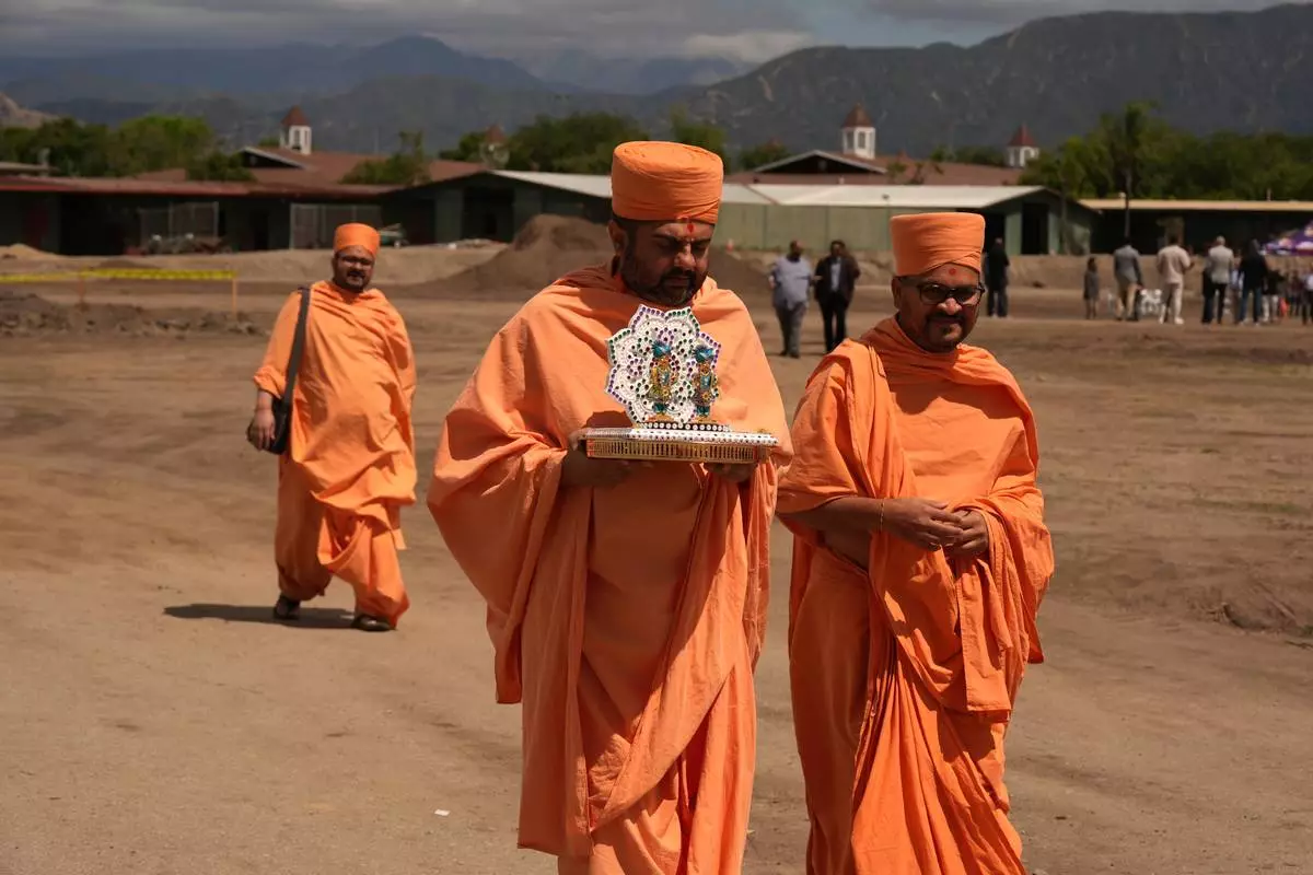 BAPS Shri Swaminarayan Mandir temple Hindu monks walk after performing a Puja ceremony, a traditional blessing ritual for the groundbreaking ceremony for the official home field for the Los Angeles Knight Riders for 2026, and the future venue of the LA 2028 Olympics Fairgrounds Cricket Stadium at the Pomona Fairplex in Pomona, Calif., Wednesday, April 22, 2026. (AP Photo/Damian Dovarganes)