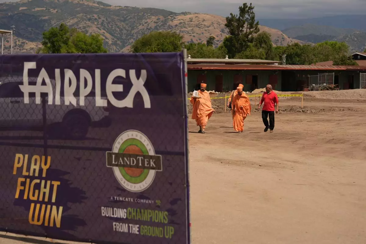 BAPS Shri Swaminarayan Mandir temple Hindu monks walk after performing a Puja ceremony, a traditional blessing ritual for the groundbreaking ceremony for the official home field for the Los Angeles Knight Riders for 2026, and the future venue of the LA 2028 Olympics Fairgrounds Cricket Stadium at the Pomona Fairplex in Pomona, Calif., Wednesday, April 22, 2026. (AP Photo/Damian Dovarganes)