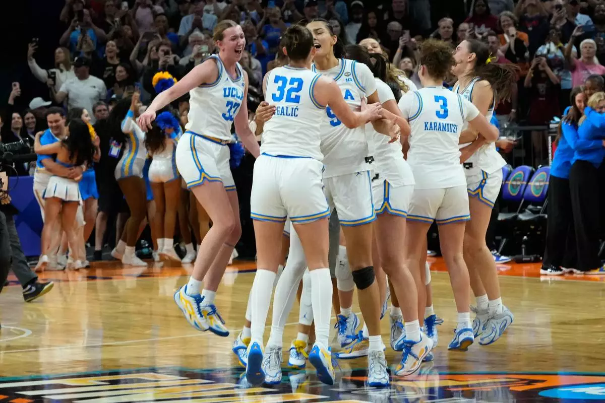 UCLA players celebrate after defeating South Carolina in the women's National Championship Final Four NCAA college basketball tournament game, Sunday, April 5, 2026, in Phoenix. (AP Photo/Ross D. Franklin)