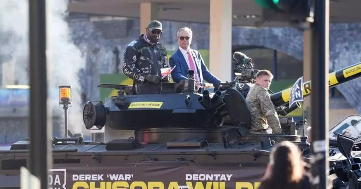 Heavyweight boxer Derek Chisora rides army tank with Nigel Farage to press event