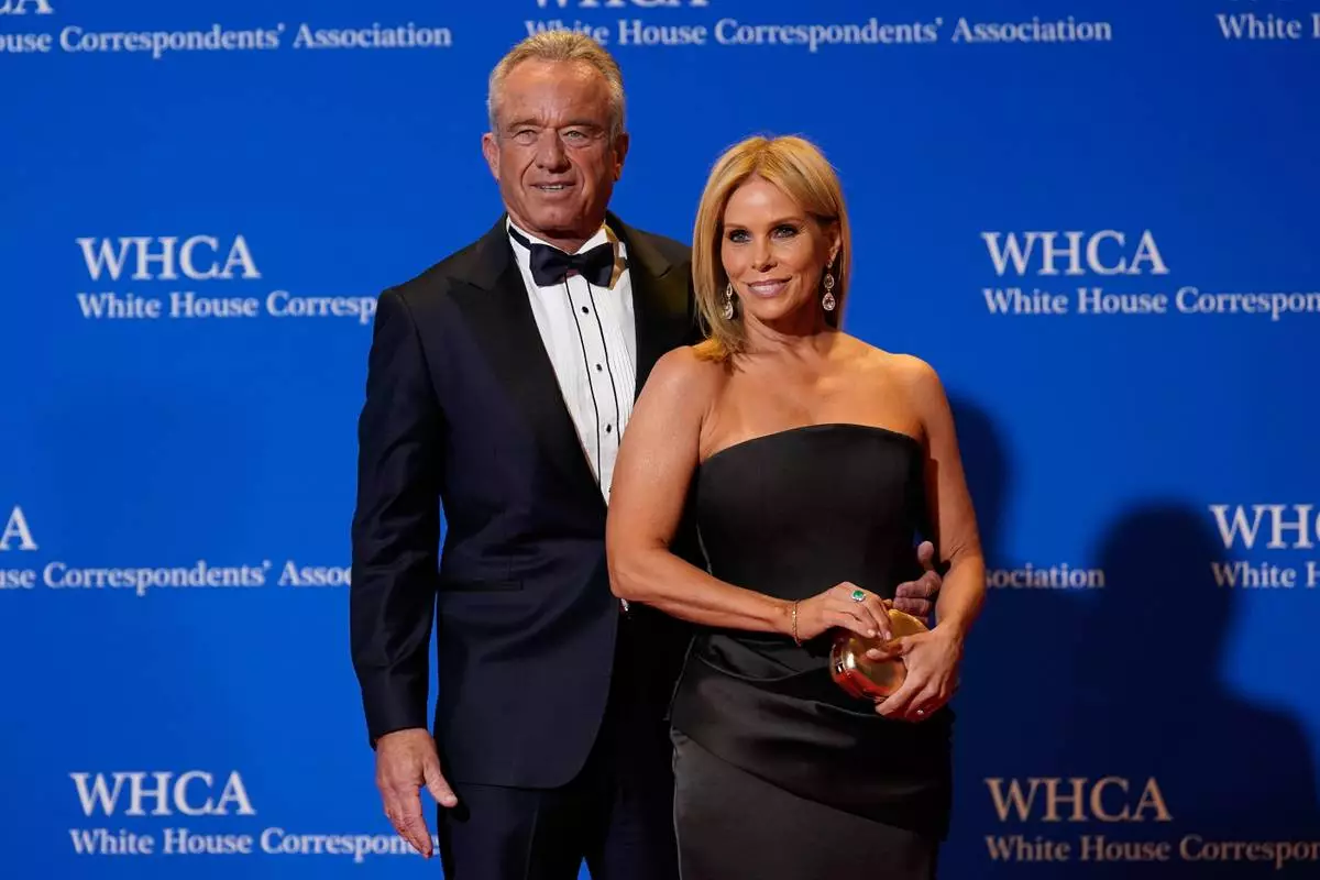 Health and Human Services Secretary Robert F. Kennedy Jr. and his wife Cheryl Hines pose for photographers at the annual White House Correspondents' Association Dinner, Saturday, April 25, 2026, in Washington. (AP Photo/Jose Luis Magana)