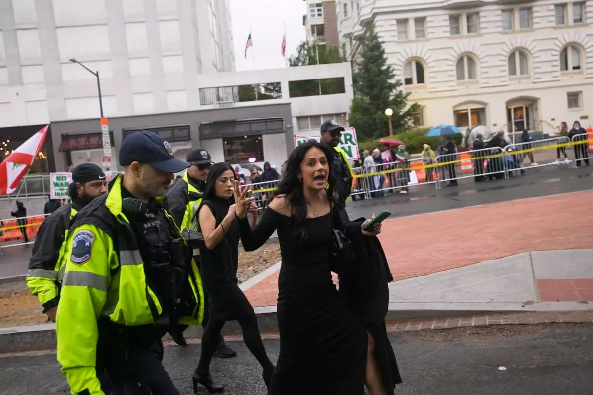 A woman is escorted from the White House Correspondents' Dinner, Saturday, April 25, 2026, in Washington. (AP Photo/Rod Lamkey, Jr.)