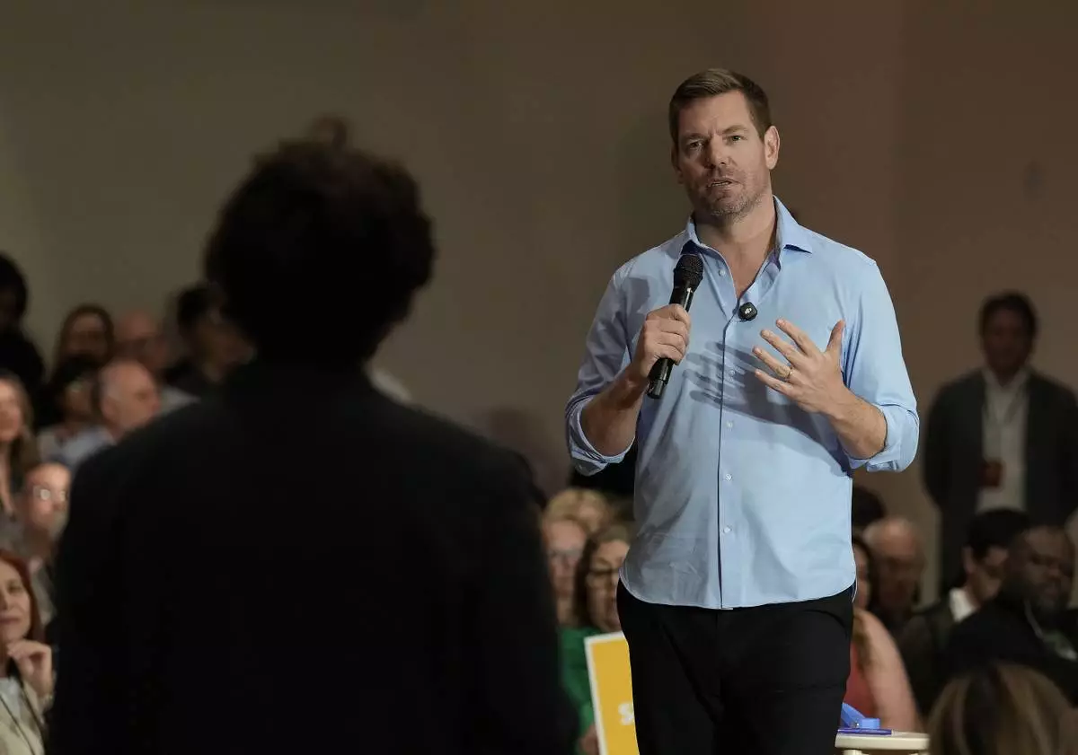 California gubernatorial candidate, Rep. Eric Swalwell, D-CA answers a question from University of California, Davis, student, Patrick Mason, during a town hall meeting in Sacramento, Calif., Tuesday, April 7, 2026. (AP Photo/Rich Pedroncelli)