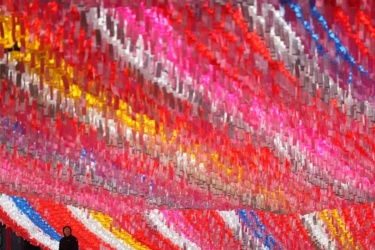 A man prepares to attach a name tag of a Buddhist who made donation to a lantern for the celebration of upcoming Buddha's birthday on May 24 at at Jogye temple in Seoul, South Korea, Tuesday, April 7, 2026. (AP Photo/Lee Jin-man)