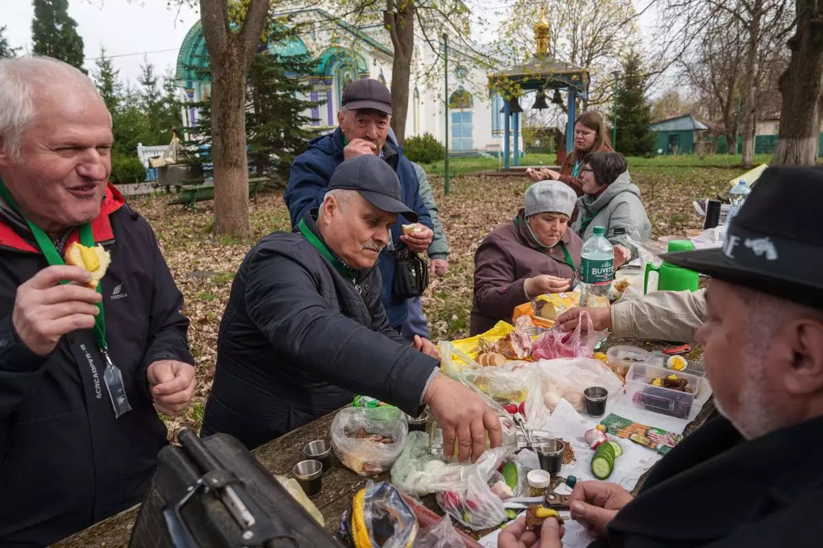 Volodymyr Vechirko, 62, one of the workers sent to clean up contamination from the Chernobyl nuclear power plant, pours vodka during lunch near the plant, Tuesday, April 21, 2026. In Chernobyl, Ukraine. (AP Photo/Evgeniy Maloletka)
