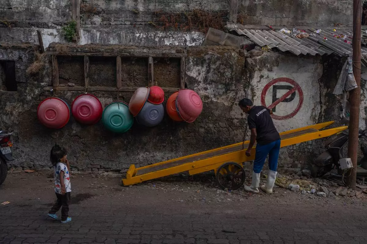 Empty fishing baskets are seen hanging on the wall outside a fish market at Sassoon Dock In Mumbai, India, Wednesday, April 8, 2026. (AP Photo/Rafiq Maqbool)