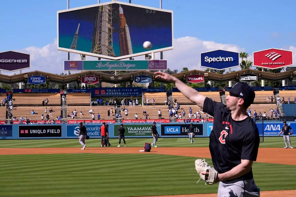 Members of the Cleveland Guardians warm up as NASA'S Artemis ll rocket is seen prior to launch from Launch Complex 39B at Kennedy Space Center on the big screen above them prior to a baseball game against the Los Angeles Dodgers, Wednesday, April 1, 2026, in Los Angeles. (AP Photo/Mark J. Terrill)