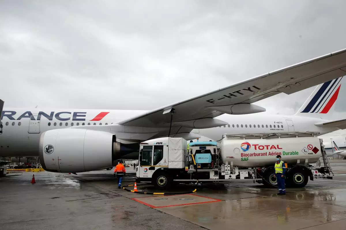 FILE - Workers refuel an Airbus A350 with sustainable aviation fuel at Roissy airport, north of Paris, Tuesday, May 18, 2021. (AP Photo/Christophe Ena, File)