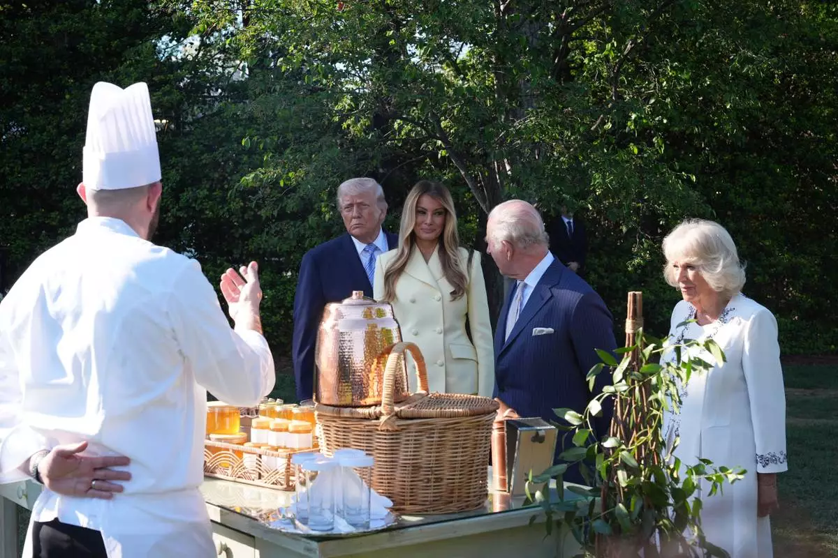 President Donald Trump and first lady Melania Trump andh Britain's King Charles III and Queen Camilla talk with White House assistant pastry chef Carlo Figarella as they look at a display at the White House garden on the South Lawn of the White House, Monday, April 27, 2026, in Washington. (AP Photo/Alex Brandon, Pool)