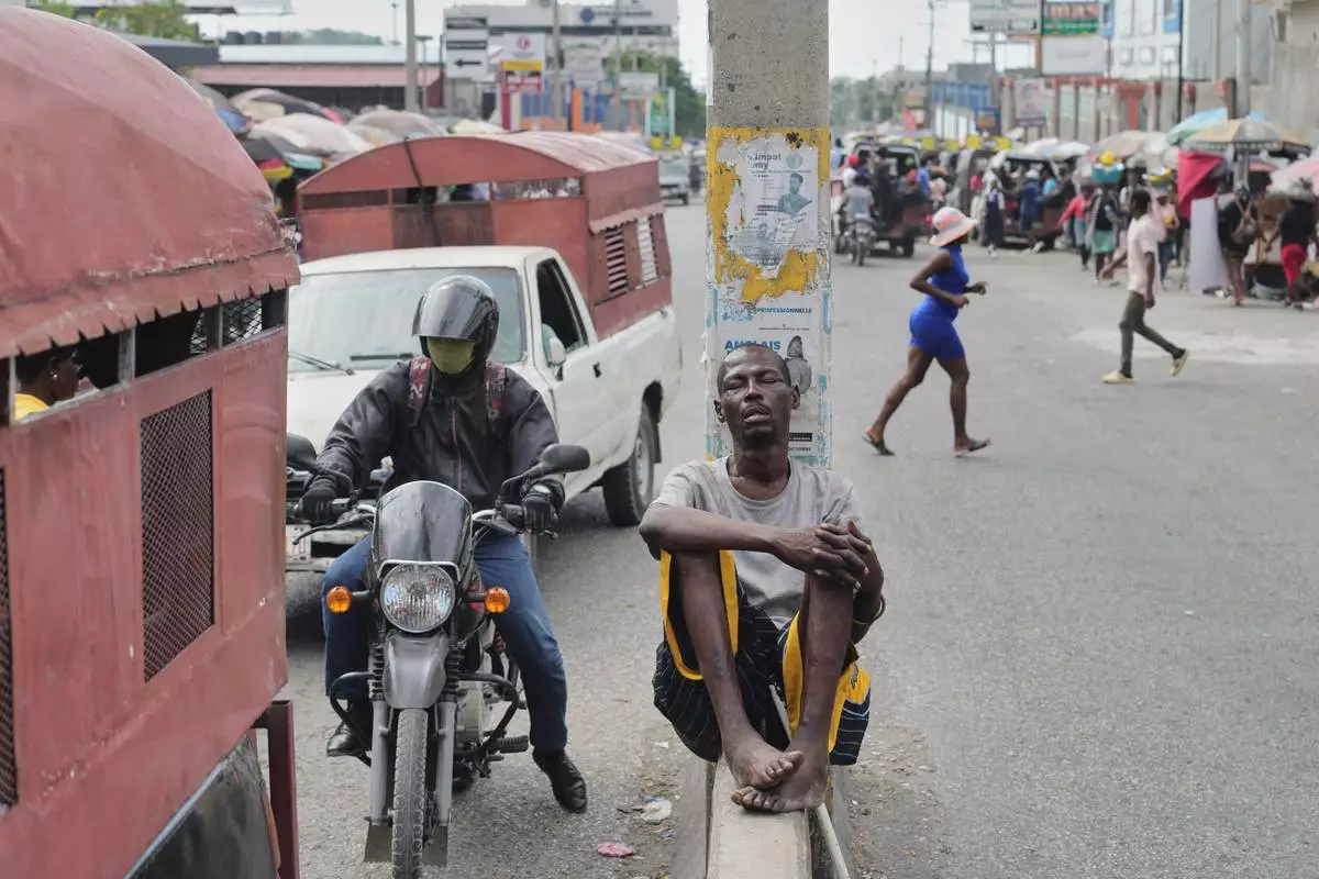 A man sleeps on a lane divider in the Delmas neighborhood of Port-au-Prince, Haiti, Thursday, April 9, 2026. (AP Photo/Odelyn Joseph)