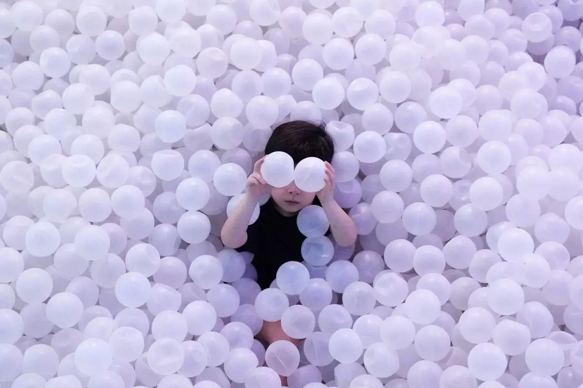 A child plays in a ball pit during an immersive exhibit at the Megapolis Outlets Center in Panama City, Tuesday, April 7, 2026. (AP Photo/Matias Delacroix)