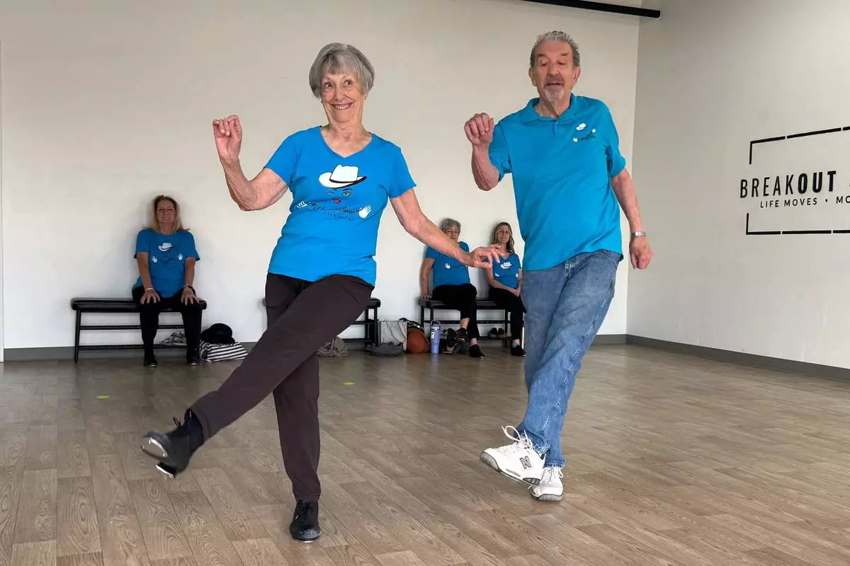 The Rodeo City Wreckettes' Carol Ross 87, and her husband, John, 87, perform a dance to the song, “Let’s Chase Each Other ‘round the Room Tonight" on Thursday, April 16, 2026, in Tucson, Ariz. (Anita Snow via AP) CORRECTION: John Ross' age corrected to 87 from 89.
