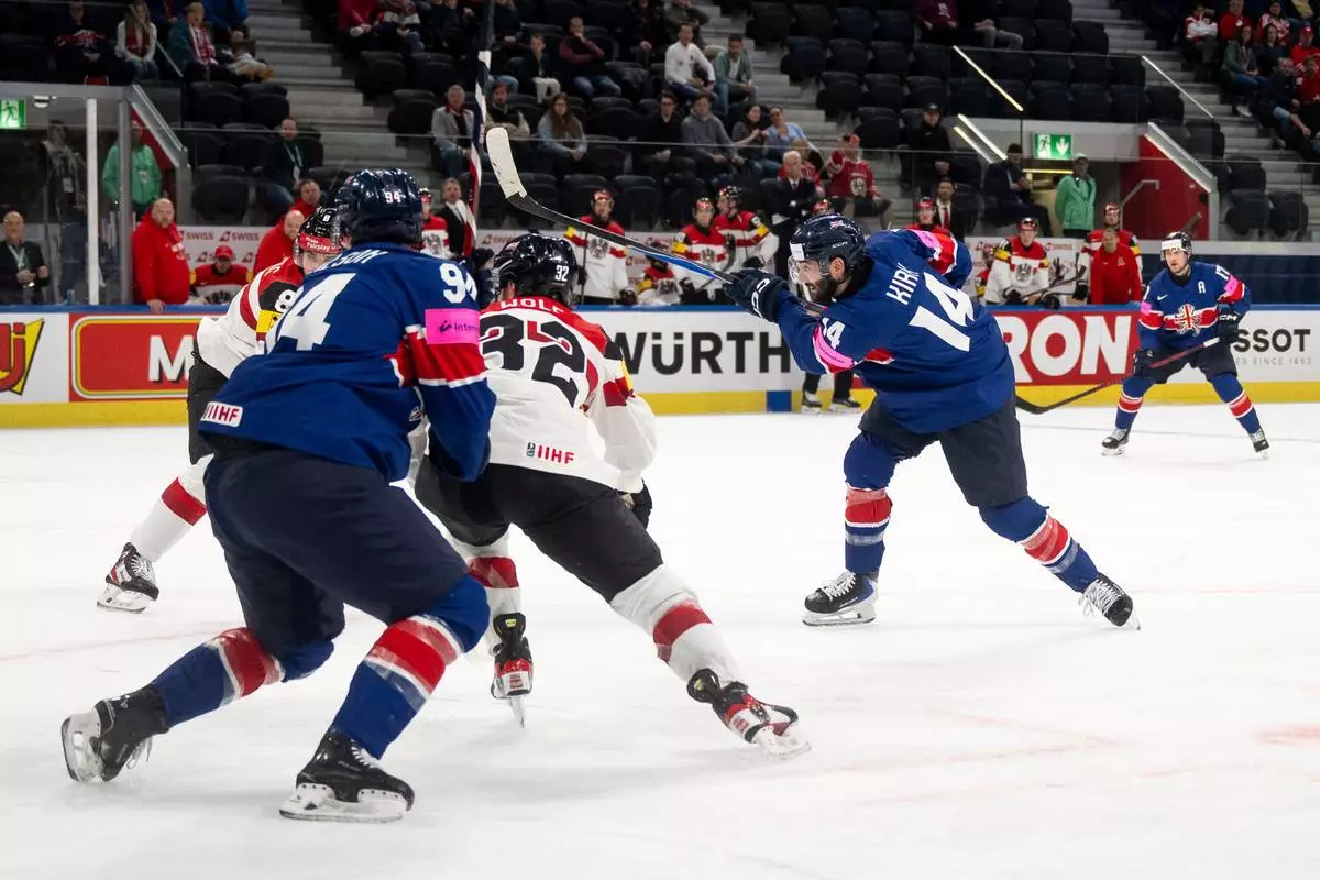 Britain's Liam Kirk, right, scores his team's second goal, during the 2026 IIHF Men's Ice Hockey World Championship preliminary round group A game between Britain and Austria, in Zurich, Switzerland, Saturday, May 16, 2026. (Andreas Becker/Keystone via AP)