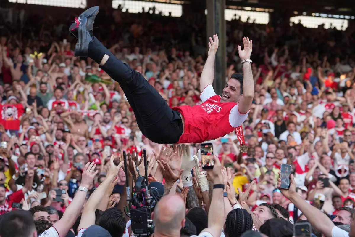 Arsenal's manager Mikel Arteta is thrown in the air by the players celebrating their Premier League title after the English Premier League soccer match between Crystal Palace and Arsenal in London, England, Sunday, May 24, 2026. (AP Photo/Kin Cheung)