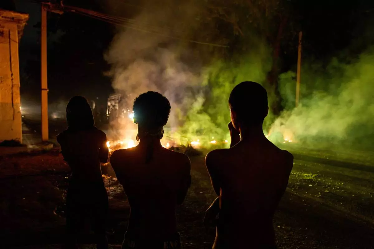 FILE - People look at a barricade set up by residents protesting against prolonged power outages in Havana, Cuba, May 13, 2026. (AP Photo/Ramon Espinosa, File)
