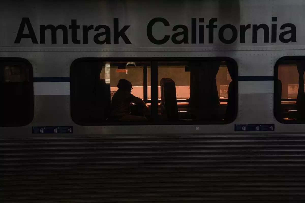 A passenger sits aboard an Amtrak train at Union Station in Los Angeles, Thursday, April 30, 2026. (AP Photo/Jae C. Hong)