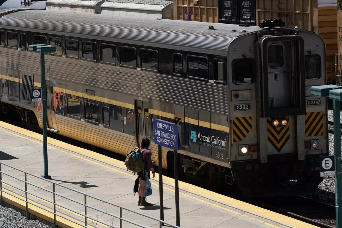 A passenger waits to board an Amtrak train at a station in Emeryville, Calif., Thursday, April 30, 2026. (AP Photo/Jeff Chiu)