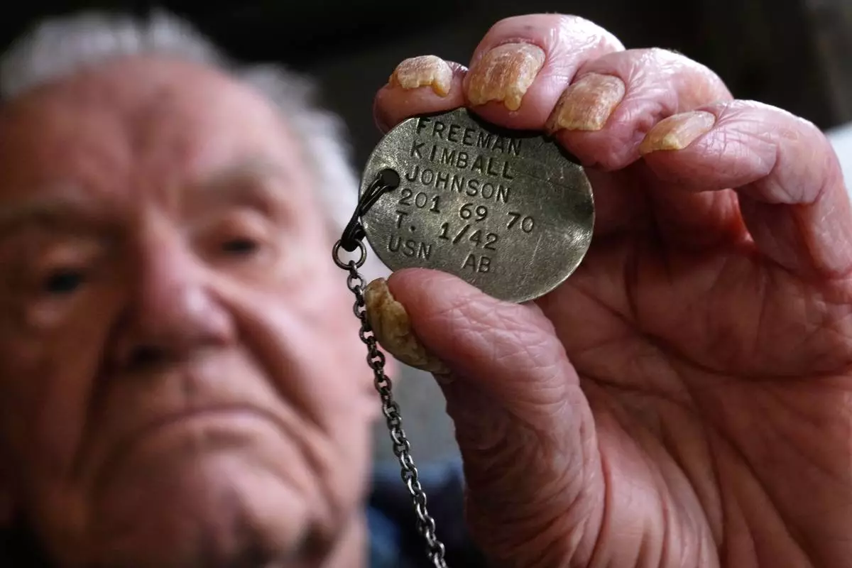 Freeman K. Johnson, a 106-year-old Pearl Harbor survivor, holds up his dog tag, May 6, 2026, in Centerville, Mass. (AP Photo/Charles Krupa)