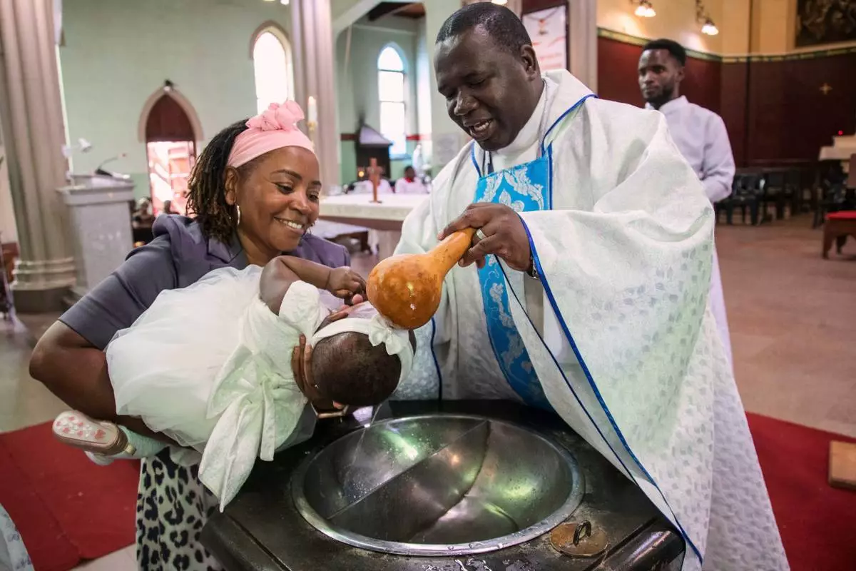 A child is baptised at the Roman Catholic Cathedral in Harare, Zimbabwe, Sunday, April 5, 2026. (AP Photo/Aaron Ufumeli)
