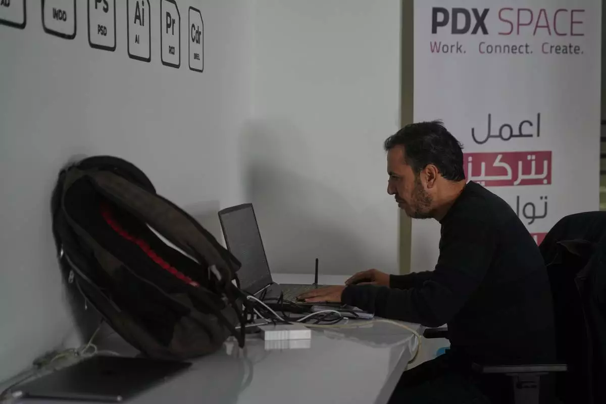 Palestinian programmer Tarik Zaeem, 44, works on his computer at a coworking space in Gaza City, March 8, 2026. (AP Photo/Abdel Kareem Hana)