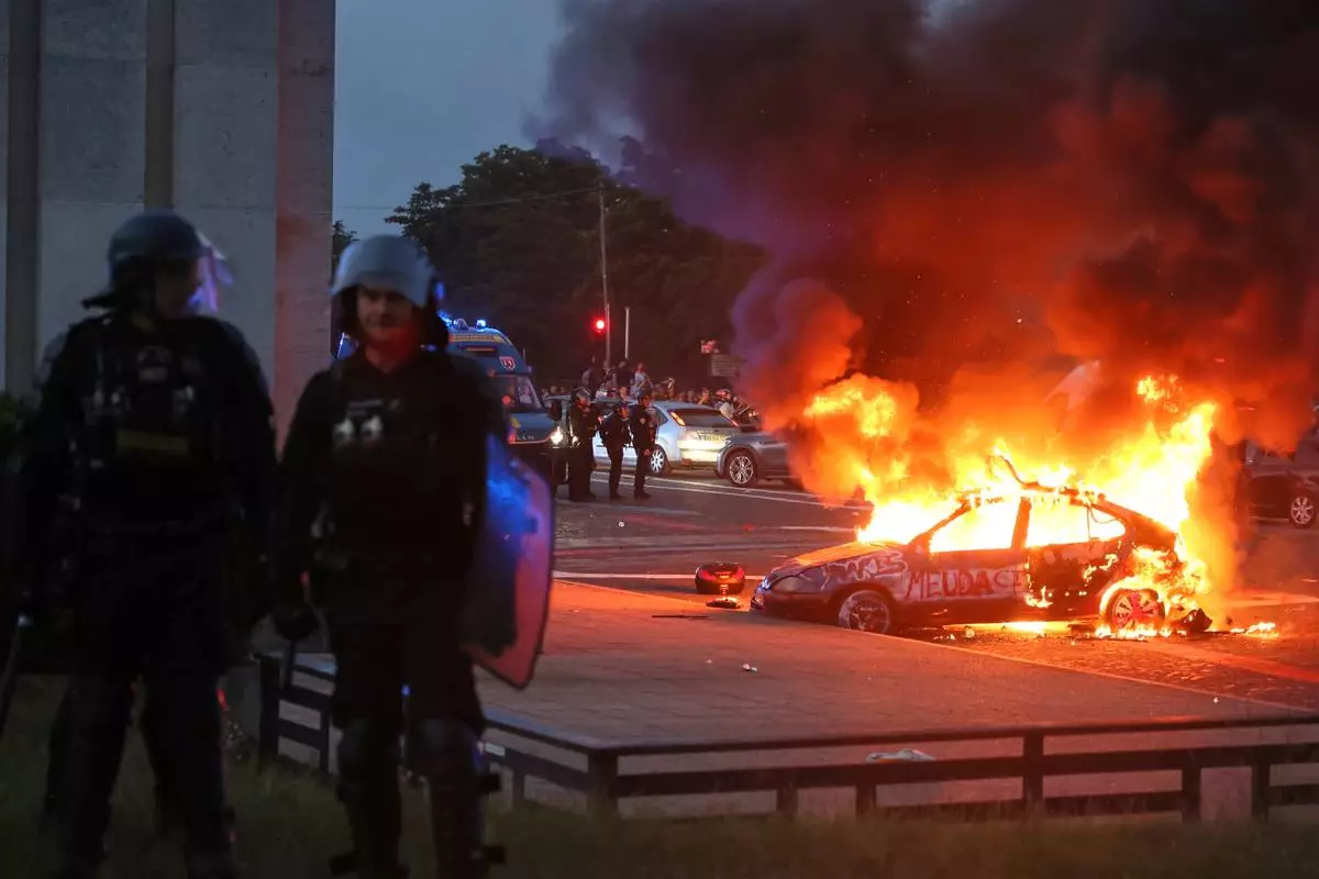A car burns as PSG supporters celebrate in Paris, Saturday, May 30, 2026 after the Champions League final soccer match between Paris Saint-Germain and Arsenal that's being played in Budapest., PSG won the game. (AP Photo/Thomas Padilla)
