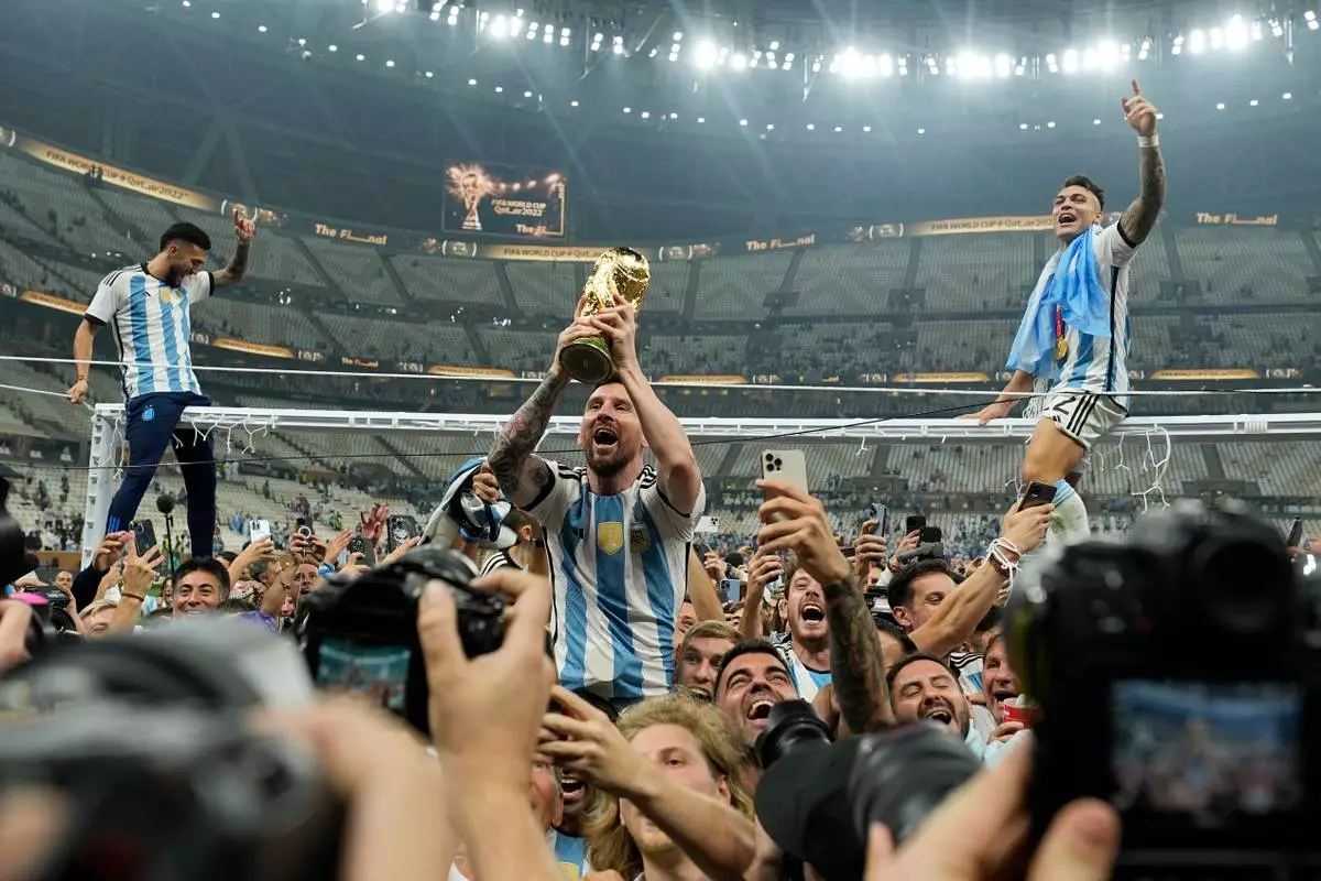 FILE - Argentina's Lionel Messi celebrates with the trophy in front of the fans after winning the World Cup final soccer match between Argentina and France at the Lusail Stadium in Lusail, Qatar, Sunday, Dec. 18, 2022. (AP Photo/Martin Meissner, FIle)