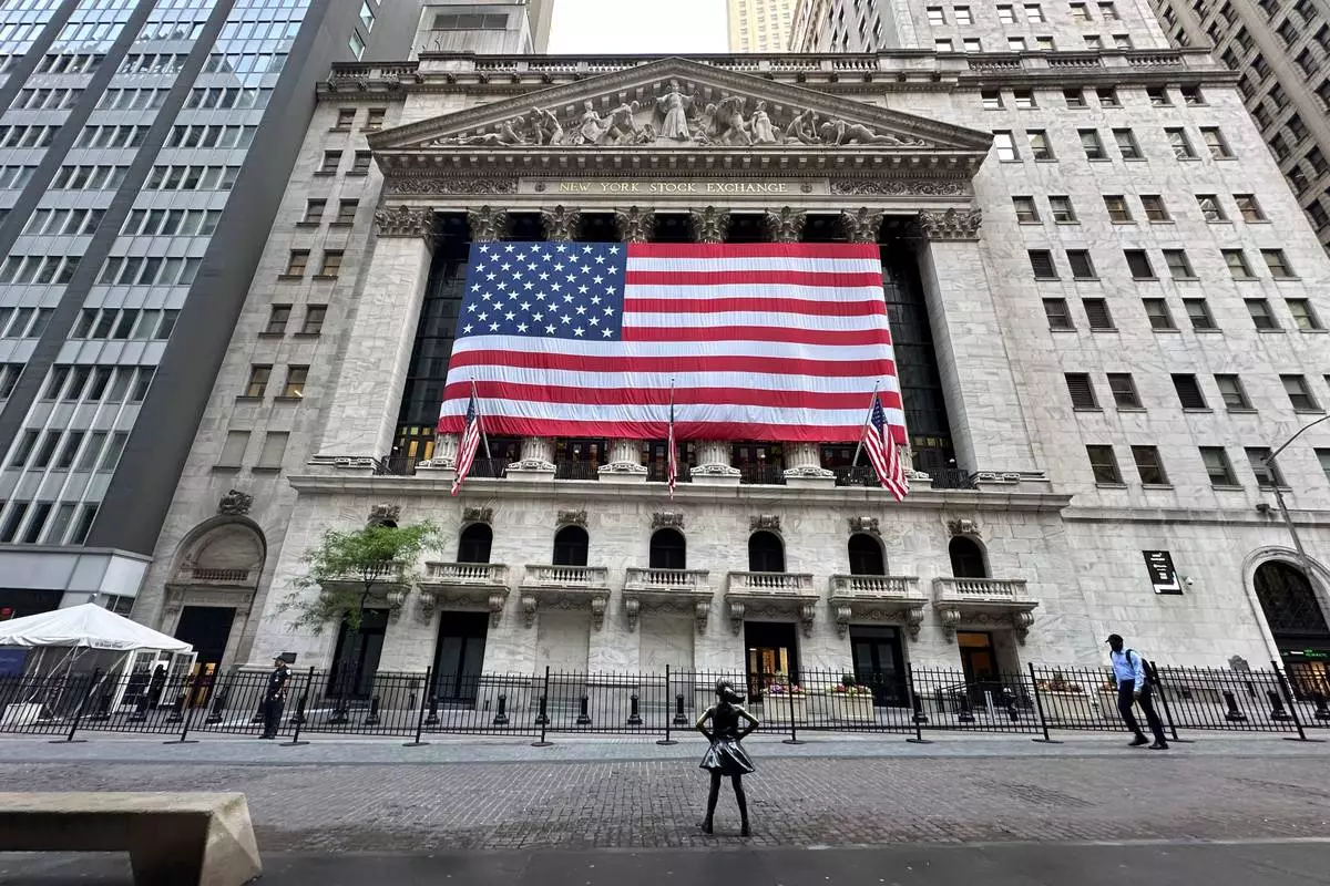 FILE - People pass the New York Stock Exchange on May 28, 2024, in New York. (AP Photo/Peter Morgan, File)