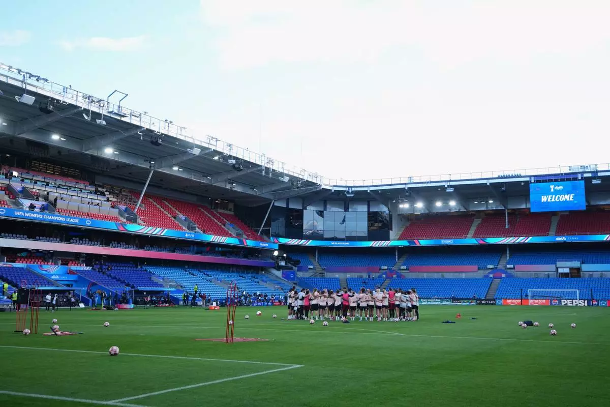 Lyonnes players and staff gather together on the pitch during a training session on the eve of the Women's Champions League final soccer match between FC Barcelona and OL Lyonnes, in Oslo, Friday, May 22, 2026. (AP Photo/Kirsty Wigglesworth)