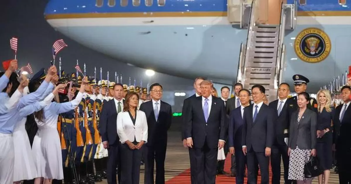 The Latest: Trump arrives in China to meet with Xi in Beijing