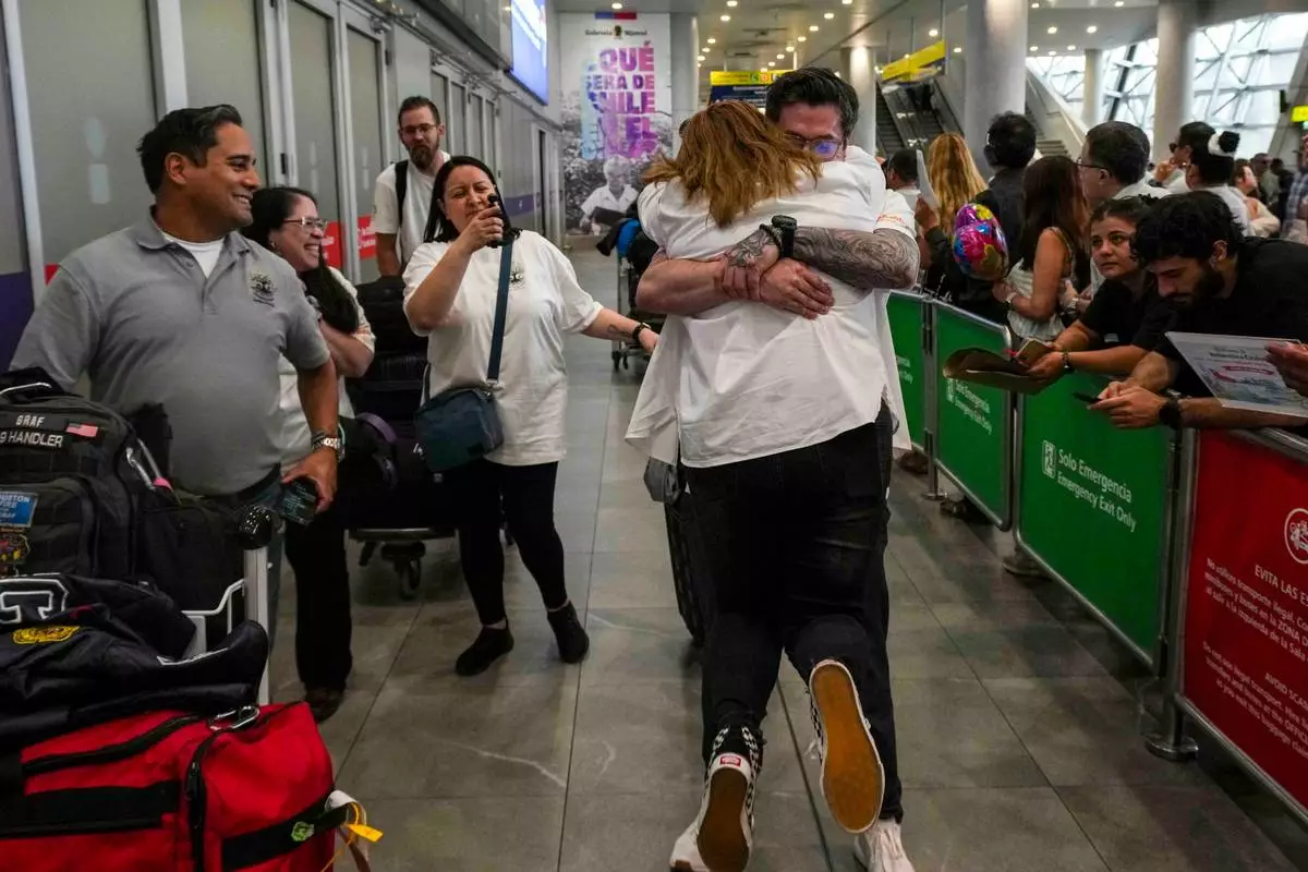 Kyle Adler, a 36-year-old Chilean American who was taken from his family at nine months old and illegally adopted, embraces his birth mother, Ana Maria Navarrete, after traveling from the U.S. to meet her for the first time, in Santiago, Chile, Saturday, Feb. 14, 2026. (AP Photo/Esteban Felix)