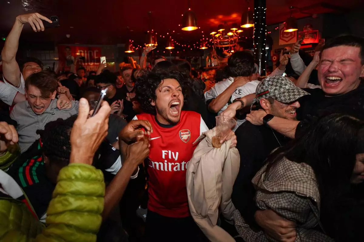 Arsenal supporters celebrate in a pub near the Arsenal stadium after Arsenal's soccer team won the Premier League title in London, Tuesday, May 19, 2026.(AP Photo/Alberto Pezzali)