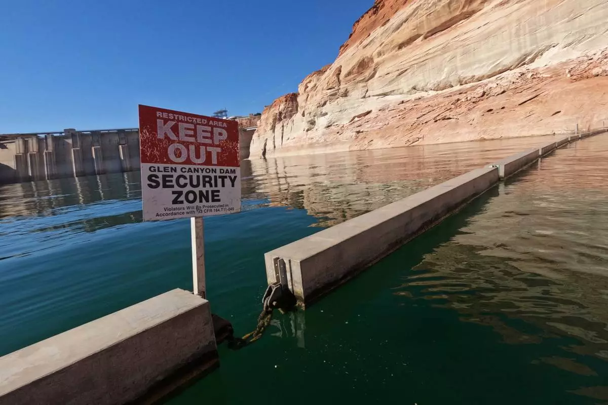 FILE - A sign reading "keep out" is displayed just upstream of Glen Canyon Dam at Lake Powell, June 8, 2022, in Page, Ariz. (AP Photo/Brittany Peterson, File)