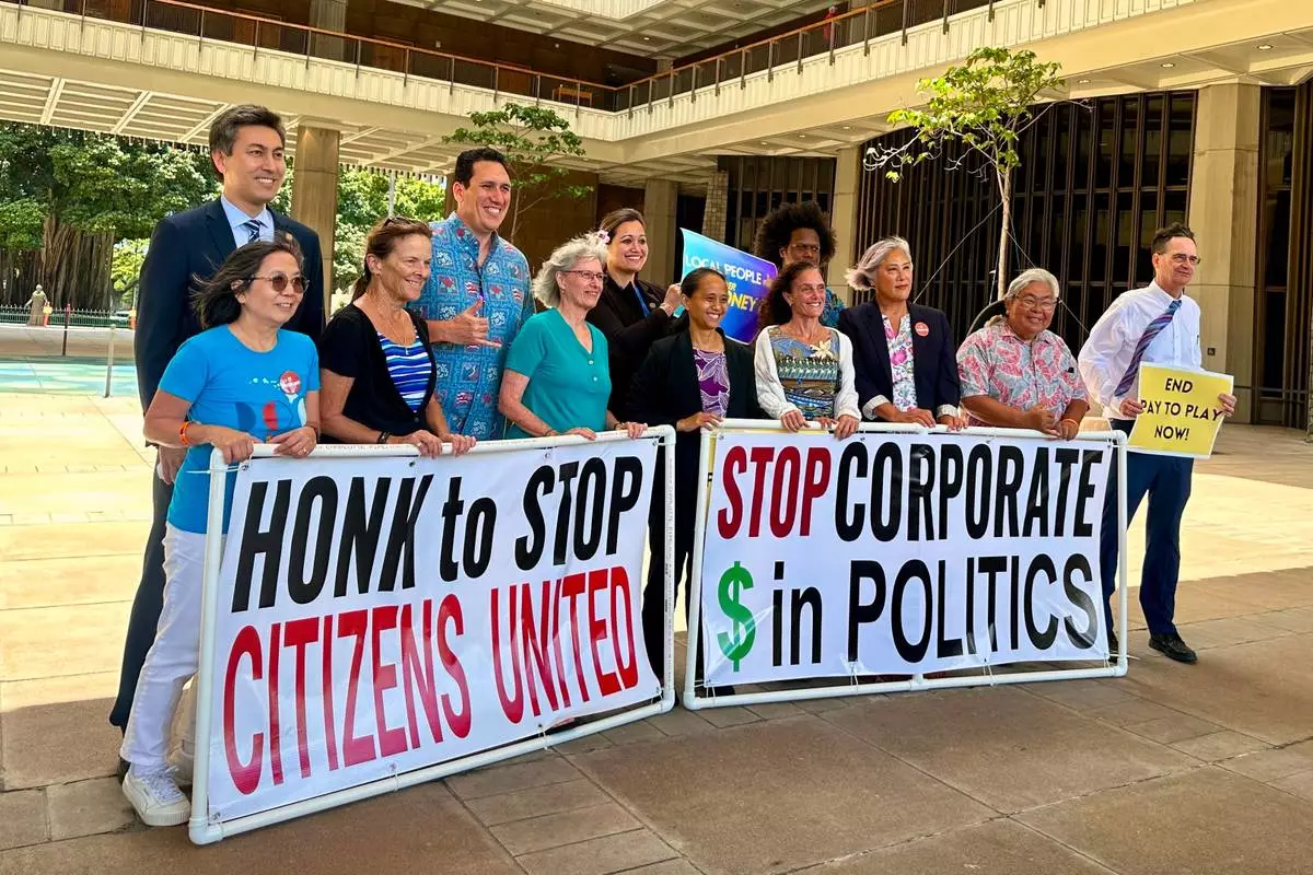 Hawaii lawmakers and activists pose for a photo after discussing a bill that seeks to limit corporate money in politics in Honolulu on Thursday, April 23, 2026. (AP Photo/Jennifer Sinco Kelleher)